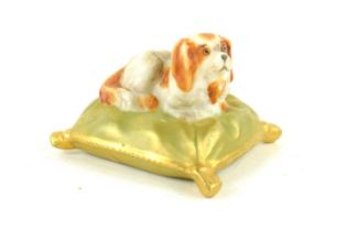 A Royal Worcester miniature model of a King Charles spaniel seated on a pillow, puce mark