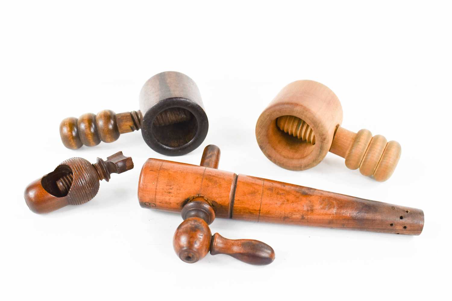 Three 19th century treen nutcrackers including one lignum vitae example, together with a treen