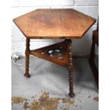 A Hexagonal mahogany Arts & Crafts side table, with cope castors, and three legs.