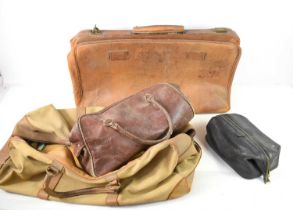 A vintage Gladstone style leather holdall together with a canvas bag and other examples. [