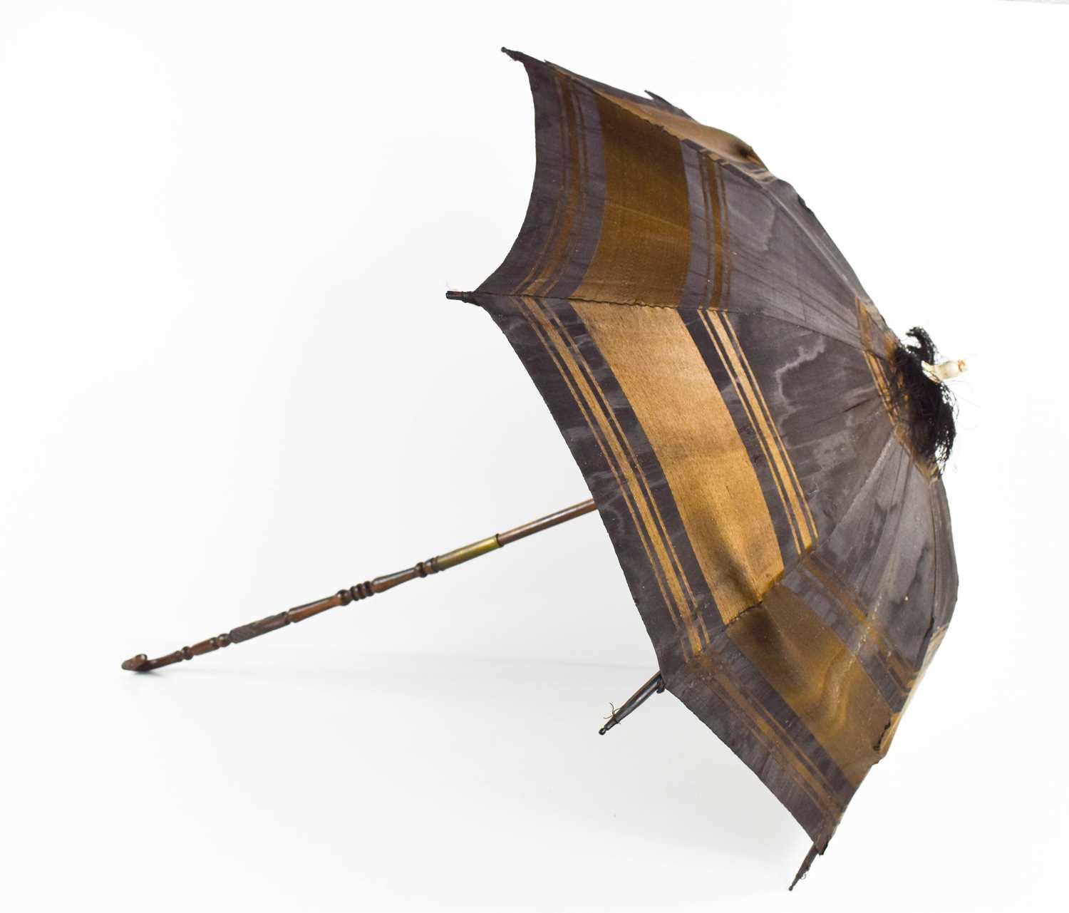 A 19th century childs parasol, the decoratively carved handle in lignum vitae, with silk shade and