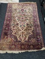 A Persian silk and wool rug, with deep red borders and dark cream ground, 132cm wide.