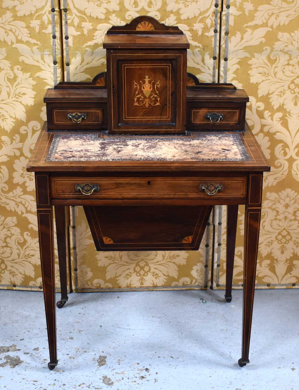 An Edwardian rosewood ladies work table, the raised back having a single cupboard door flanked by