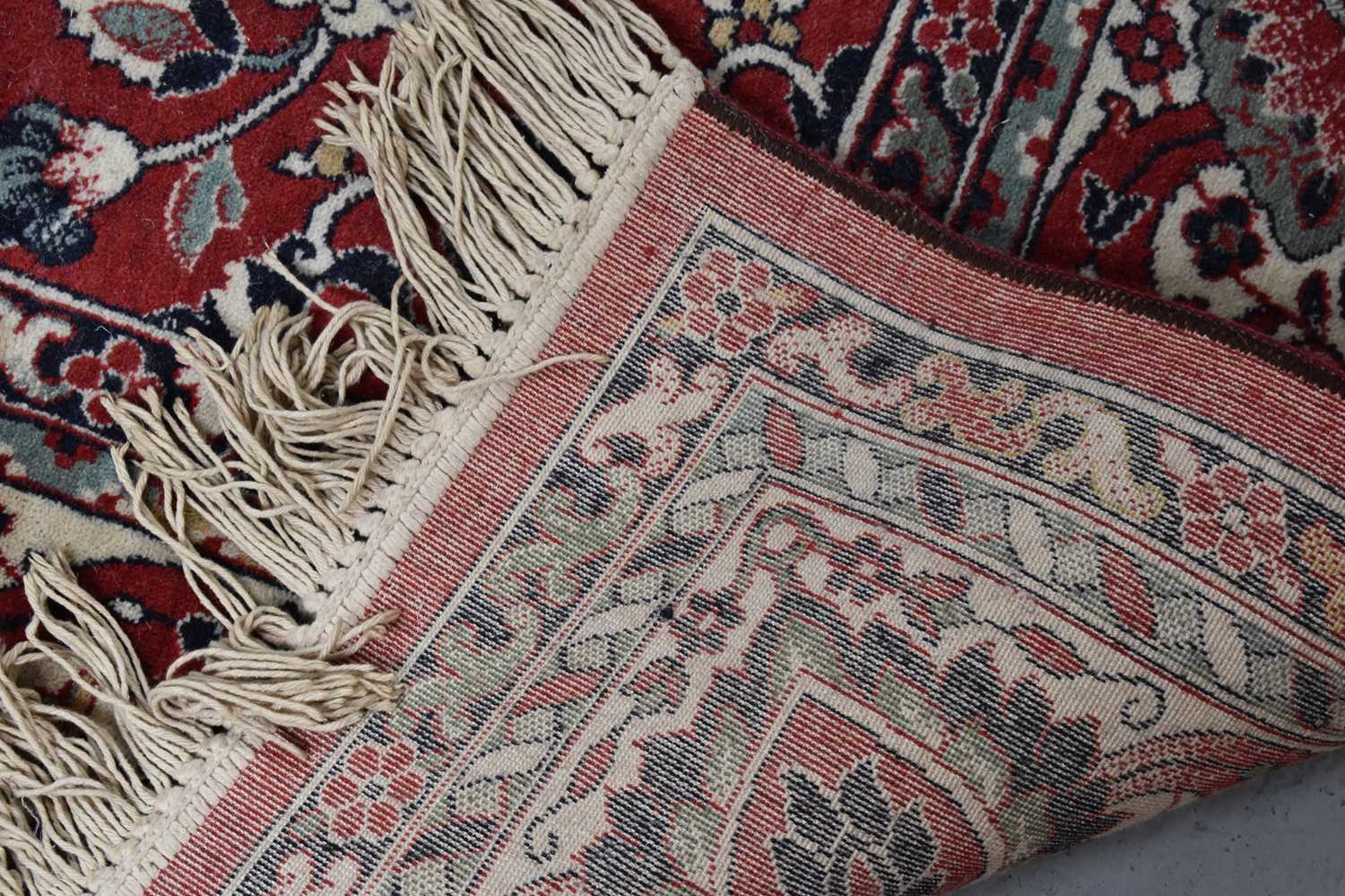 A large Middle Eastern wool rug with red ground, the centre decorated with stylised flowers with - Image 3 of 3