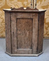 A small 19th century oak corner cupboard with single shelf interior, 40cm by 35cm by 24cm.