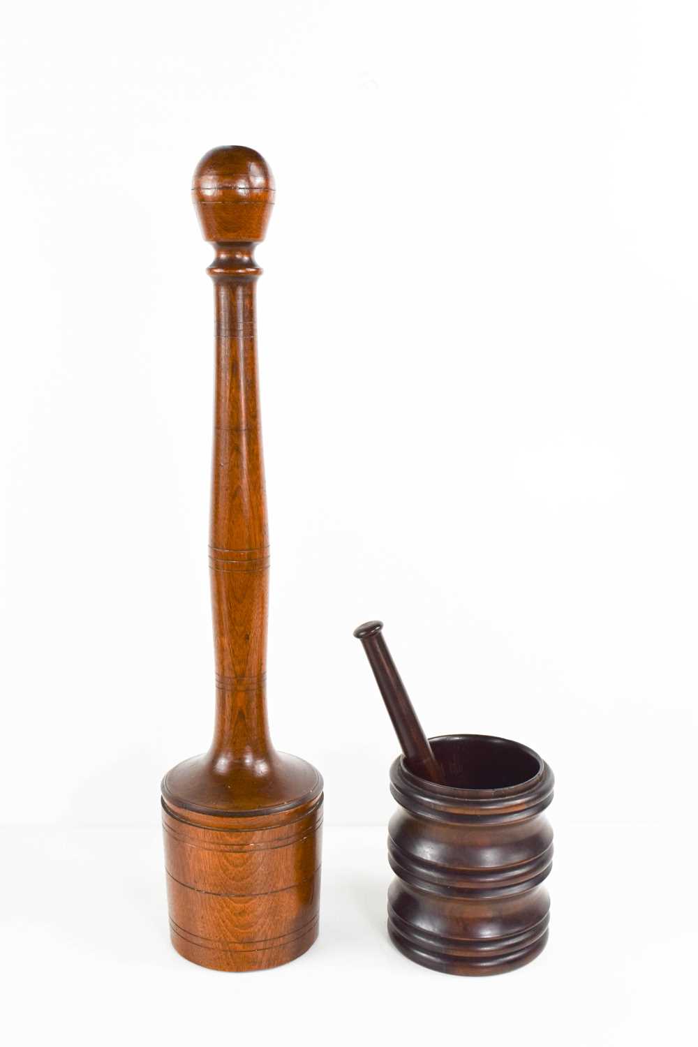 A 19th century treen potato masher, with a turned handle, and a lignum vitae mortar and matching
