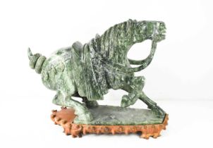 A large Chinese carved soapstone horse on hardwood stand, 48 by 20 by 42cm high including stand.