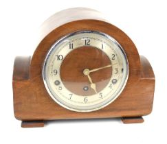 An Art Deco mahogany cased mantle clock, of curvilinear form, with Arabic numerals to the silvered