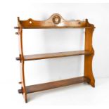 A 19th century fruitwood wall shelf, composed of a shaped and roundel carved top rail and two shaped