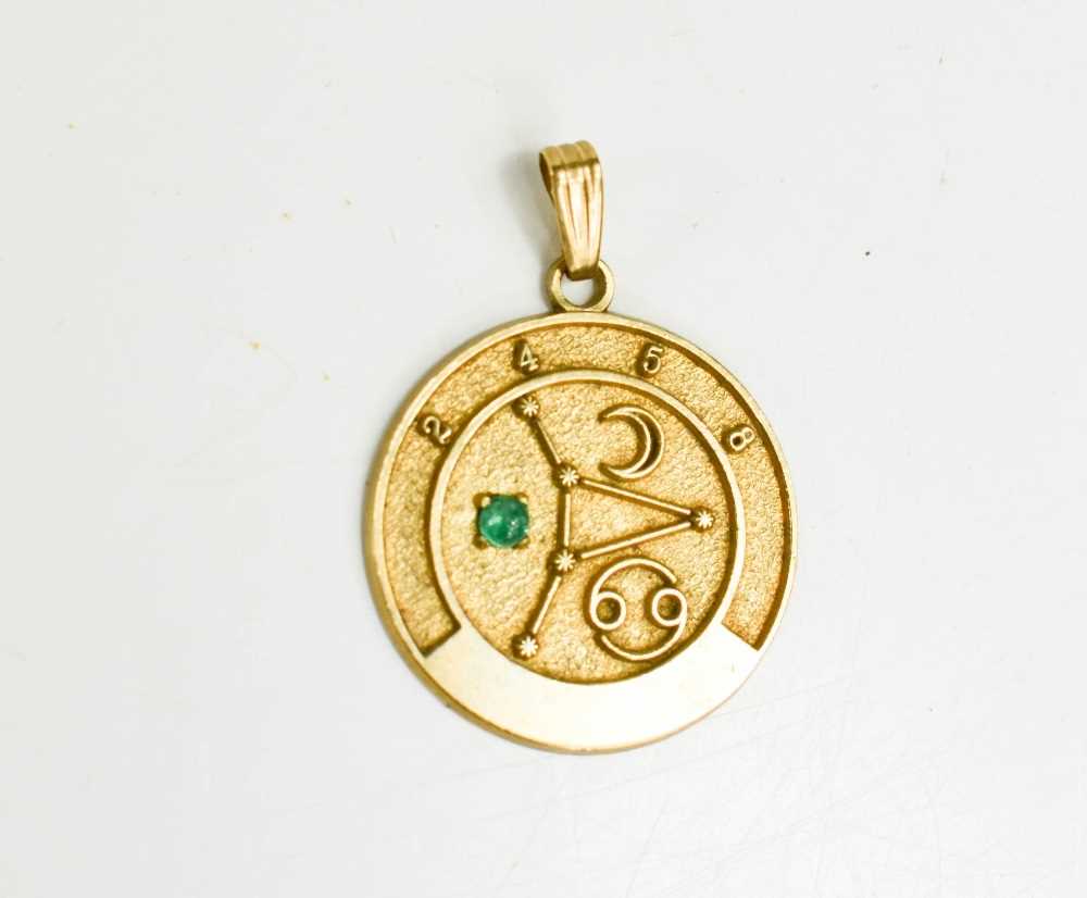 A 9ct gold astrological pendant, set with a green cabochon, 22.5mm diameter, 3.1g.
