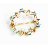 A 9ct gold, pearl and blue topaz set circular form brooch, the stones set in a decorative band, 4.