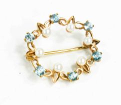 A 9ct gold, pearl and blue topaz set circular form brooch, the stones set in a decorative band, 4.