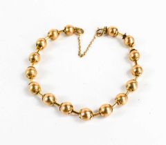 A Victorian gold bracelet of ball and bar form, each ball textured with flower finial to either end,