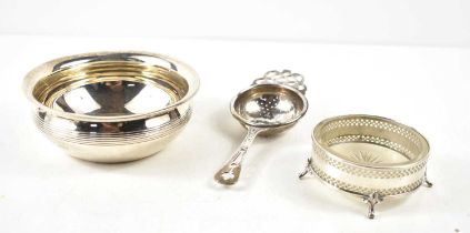 A group of silver to include a tea strainer, small bowl with gadrooned rim and a glass dish with