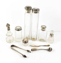 A group of silver and glass dressing table bottles, of various size and form, a pair of sugar tongs,