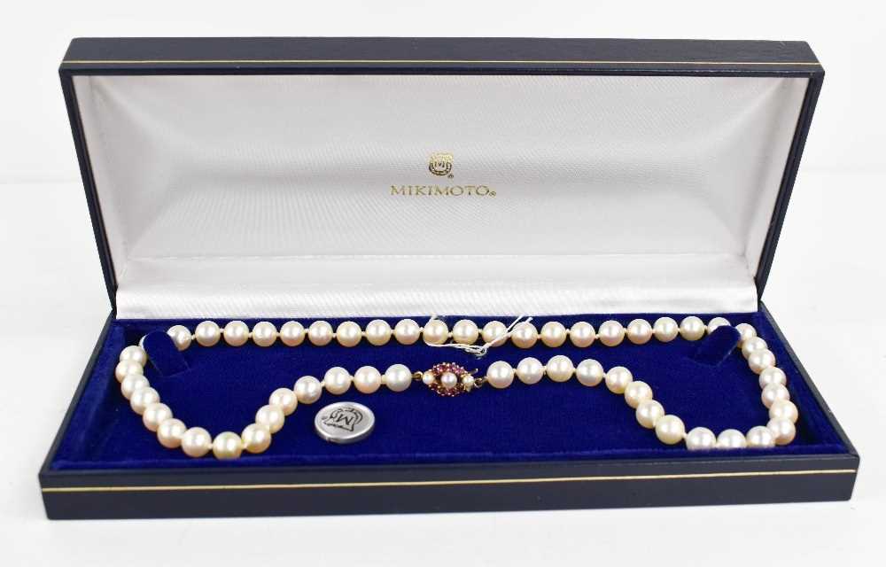 A Mikimoto pearl necklace, with a 9ct gold, pearl and pink sapphire set clasp, bearing makers