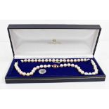 A Mikimoto pearl necklace, with a 9ct gold, pearl and pink sapphire set clasp, bearing makers