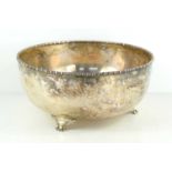 A white metal fruit bowl with gadrooned rim, on three cast feet, hallmark to underside, 23cm