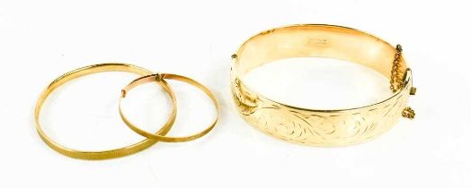 A 9ct gold baby bangle, a 9ct gold children's bangle with bronze core, and a 9ct gold plated