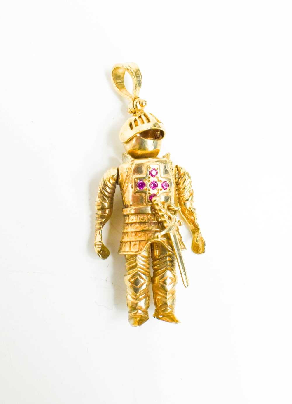 A 9ct gold knight pendant, the articulated form with five stone ruby cross to the breast-plate, 54.