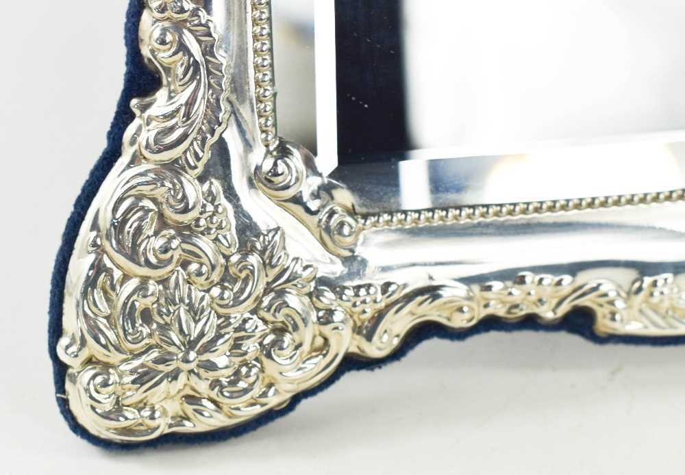 A silver table mirror, the silver embossed border of floral sprays surround the rectangular bevelled - Image 3 of 3