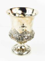 A silver urn form vase, embossed with flower and foliage, London 1868, with residual gilded