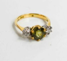 An 18ct gold three stone ring, set with central green stone, possibly garnet, with a diamond