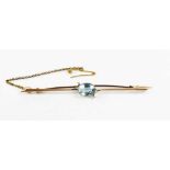 A 9ct gold bar brooch set with an oval cut aquamarine, indistinctly marked 9ct, with a safety