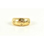 A gold and diamond gypsy ring, the four diamonds in starburst settings, indistinctly marked to the