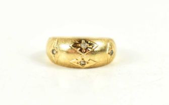 A gold and diamond gypsy ring, the four diamonds in starburst settings, indistinctly marked to the