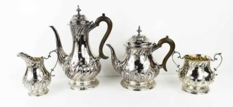 A silver tea set, embossed with Rococo style scrollwork, comprising tea pot, water pot, sugar