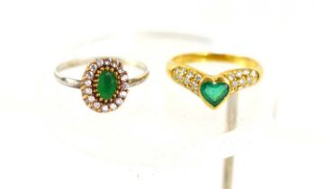 An 18ct gold, emerald and diamond ring, the heart shaped emerald flanked by eleven diamond