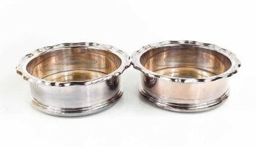 A pair of silver wine coasters with turned wooden bases, Sheffield 1964, 15cm diameter.