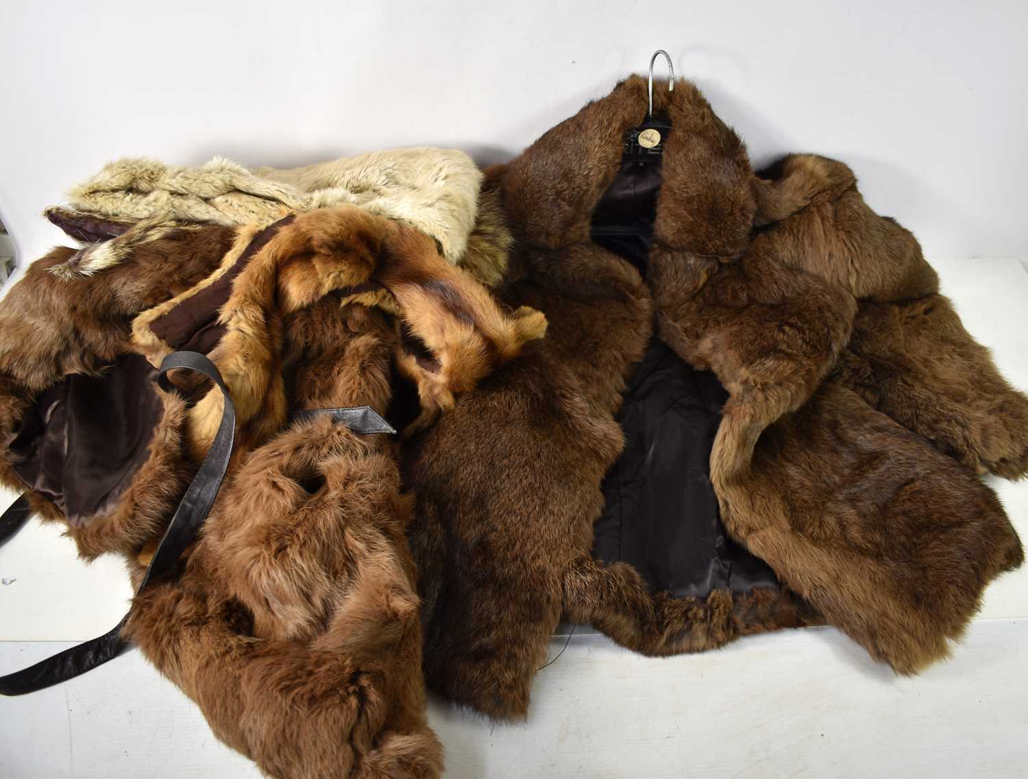 A group of vintage furs including a rabbit jacket, a mink and a fox stole.