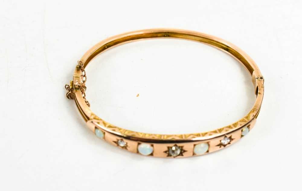 A Victorian gold, opal and diamond bangle, set with four opals, a single central diamond in a - Image 2 of 3