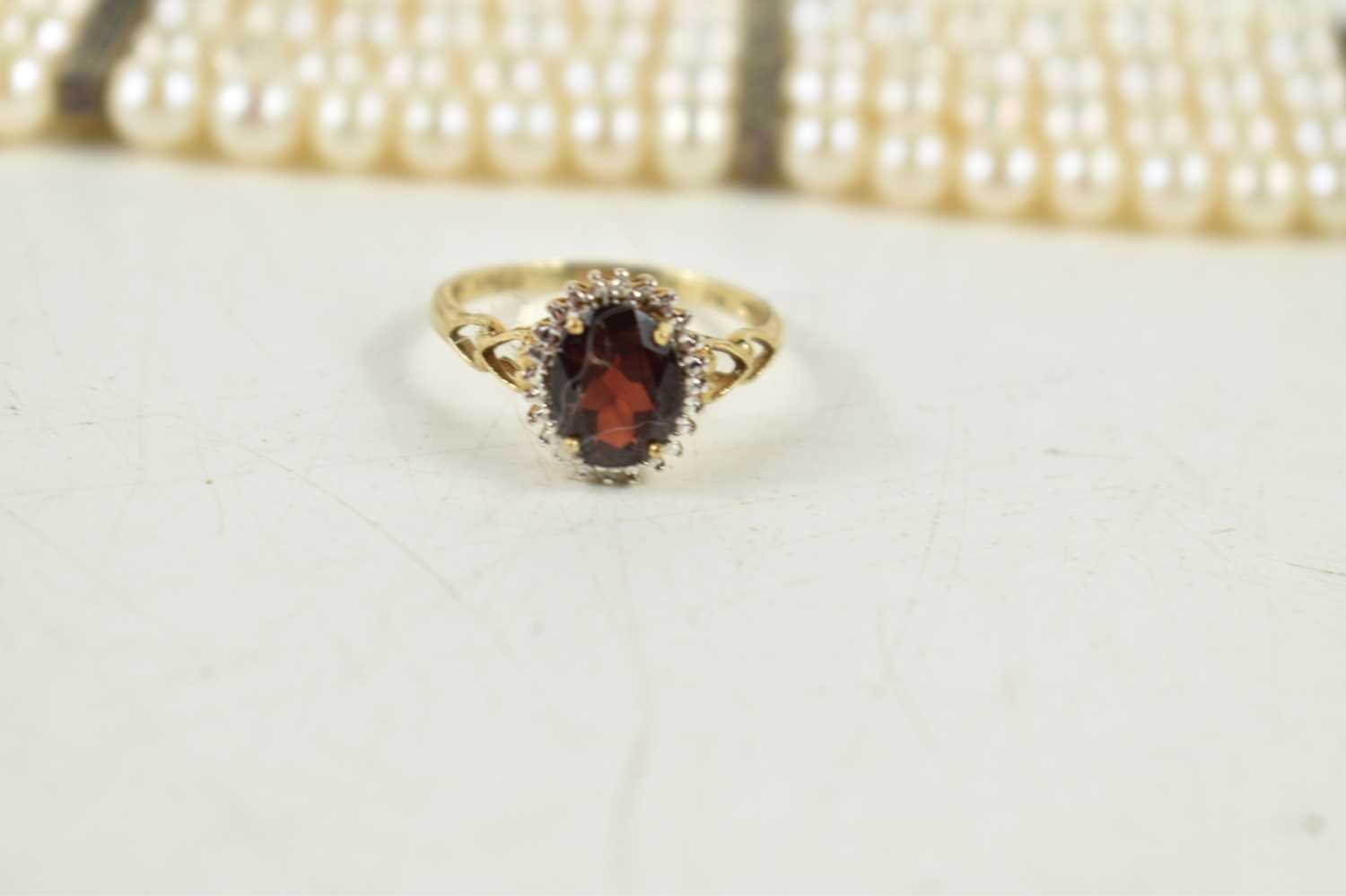 A 9ct gold, garnet and diamond cluster ring, the oval cut garnet of approximately 7 by 9mm, - Image 2 of 2