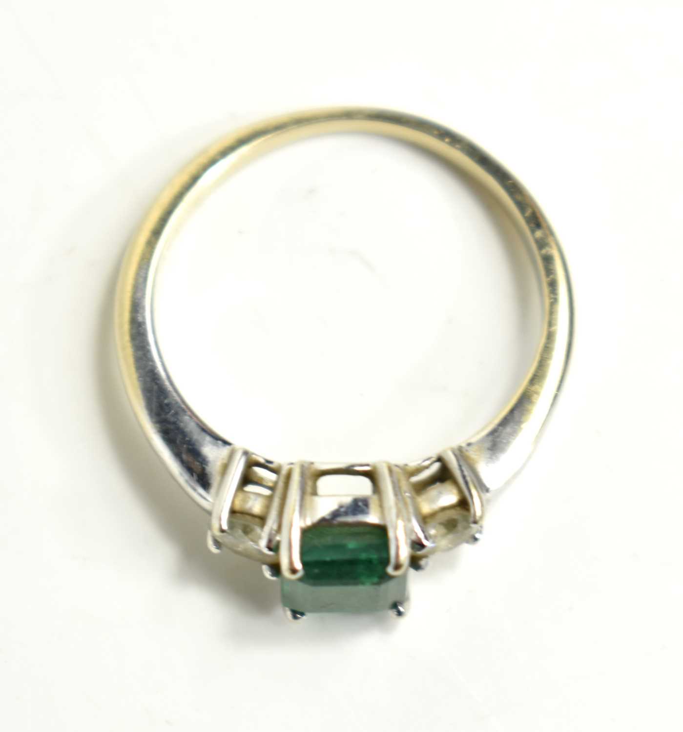 An 18ct white gold emerald and diamond, three stone ring, the emerald cut central stone of - Image 2 of 2