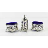 An Art Deco silver cruet set of two salts and pepper shaker, of pierced form each with blue glass