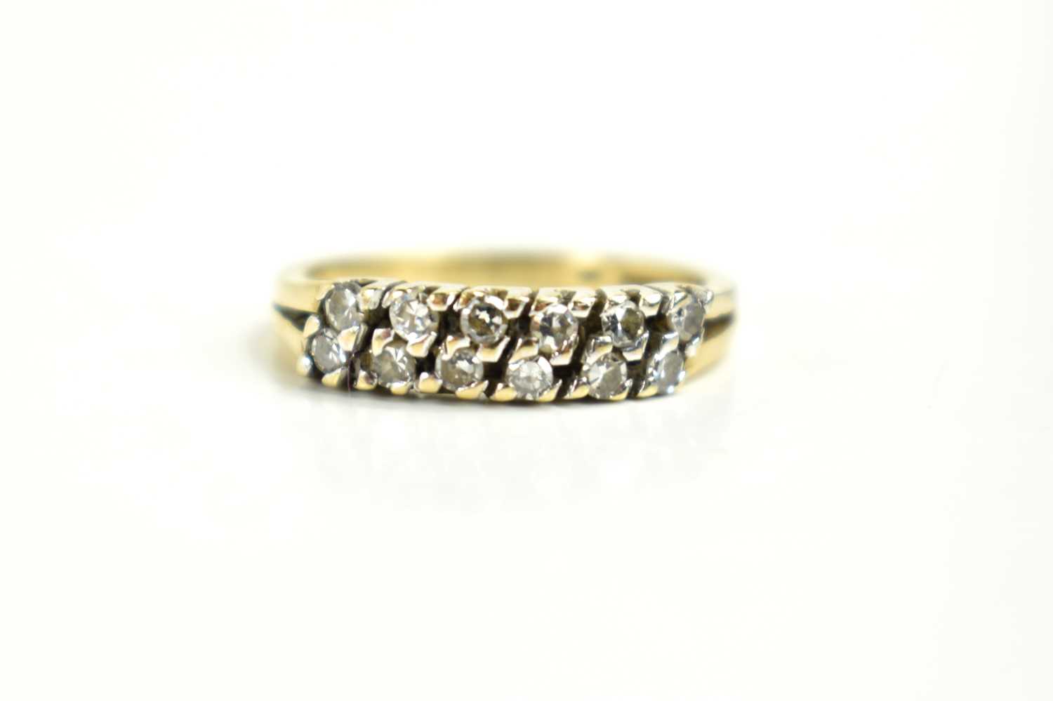 A 9ct gold and diamond twelve stone ring, the diamond brilliants set in six diagonal pairs, size