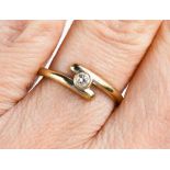 An 18ct gold and diamond ring, the bezel set solitaire of approximately 2.2mm diameter, in cross-