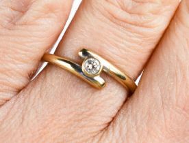 An 18ct gold and diamond ring, the bezel set solitaire of approximately 2.2mm diameter, in cross-