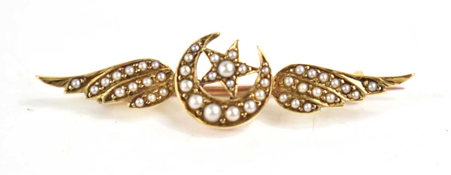 A seed pearl set brooch, of winged form with central crescent moon and star, 44mm long, unmarked,