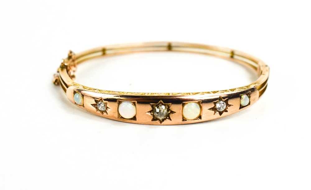 A Victorian gold, opal and diamond bangle, set with four opals, a single central diamond in a