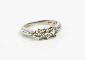 A platinum and diamond three stone ring, the brilliant cut diamonds approximately 1/18ct each,