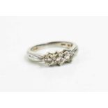 A platinum and diamond three stone ring, the brilliant cut diamonds approximately 1/18ct each,