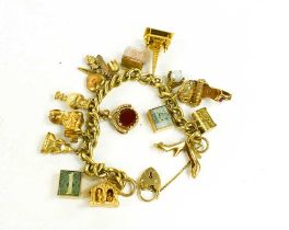 A 9ct gold curb link charm bracelet, with fifteen charms and heart shaped padlock clasp, total