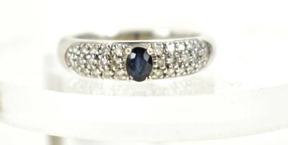 An 18ct white gold, sapphire and diamond ring, the central oval cut sapphire of approximately 4.4 by