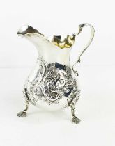 A silver jug by Robert Harper, London 1860, embossed with C-scroll and floral decoration to the