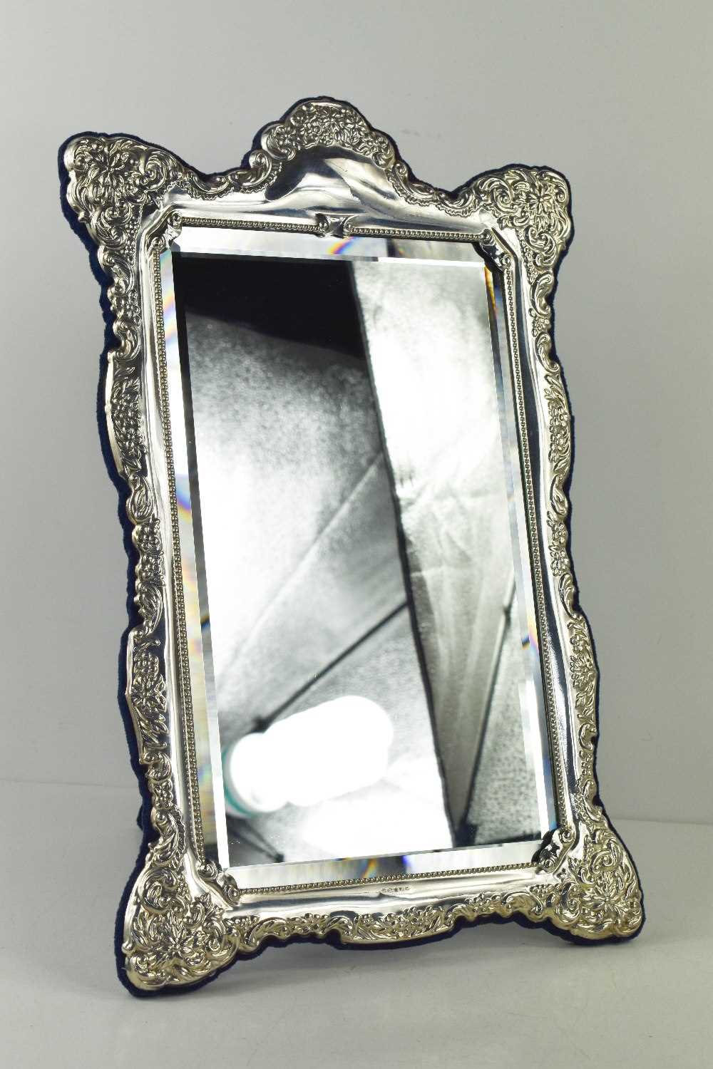 A silver table mirror, the silver embossed border of floral sprays surround the rectangular bevelled - Image 2 of 3