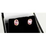 A pair of 18ct gold and pink sapphire earrings, set with oval cut stones of approximately 5.5 by 3.